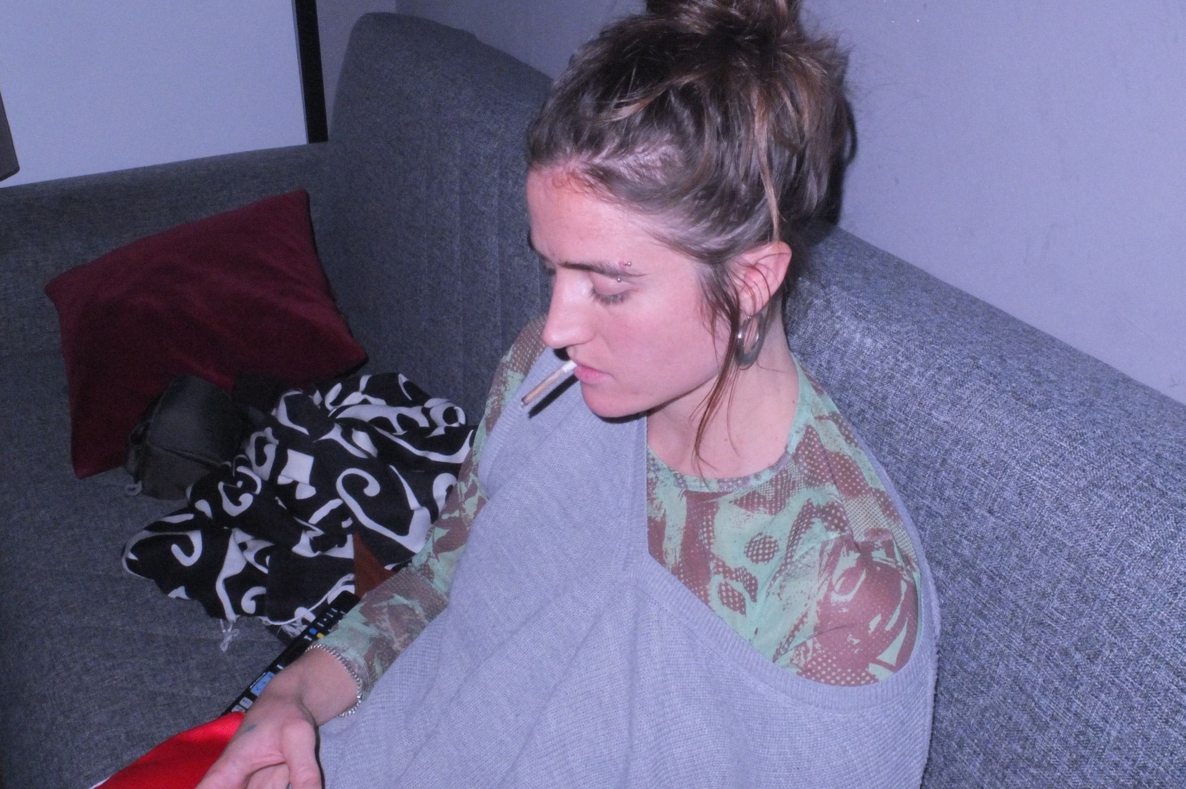 Woman lying on a sofa with a cigarette, violet light