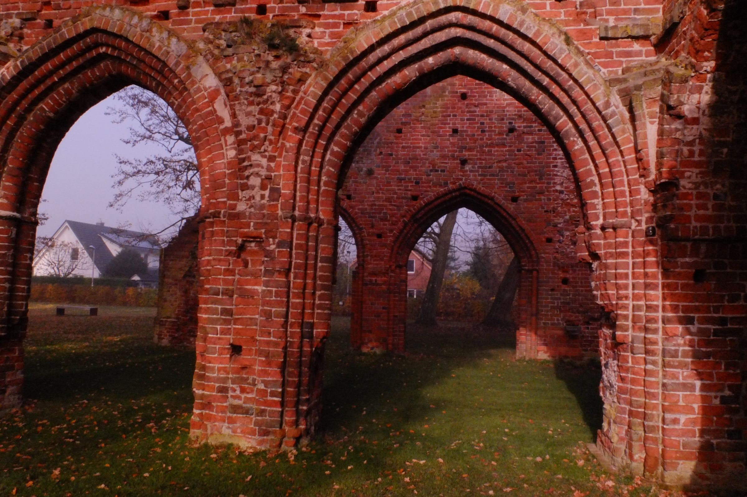 Red brick Gothic arches over grass