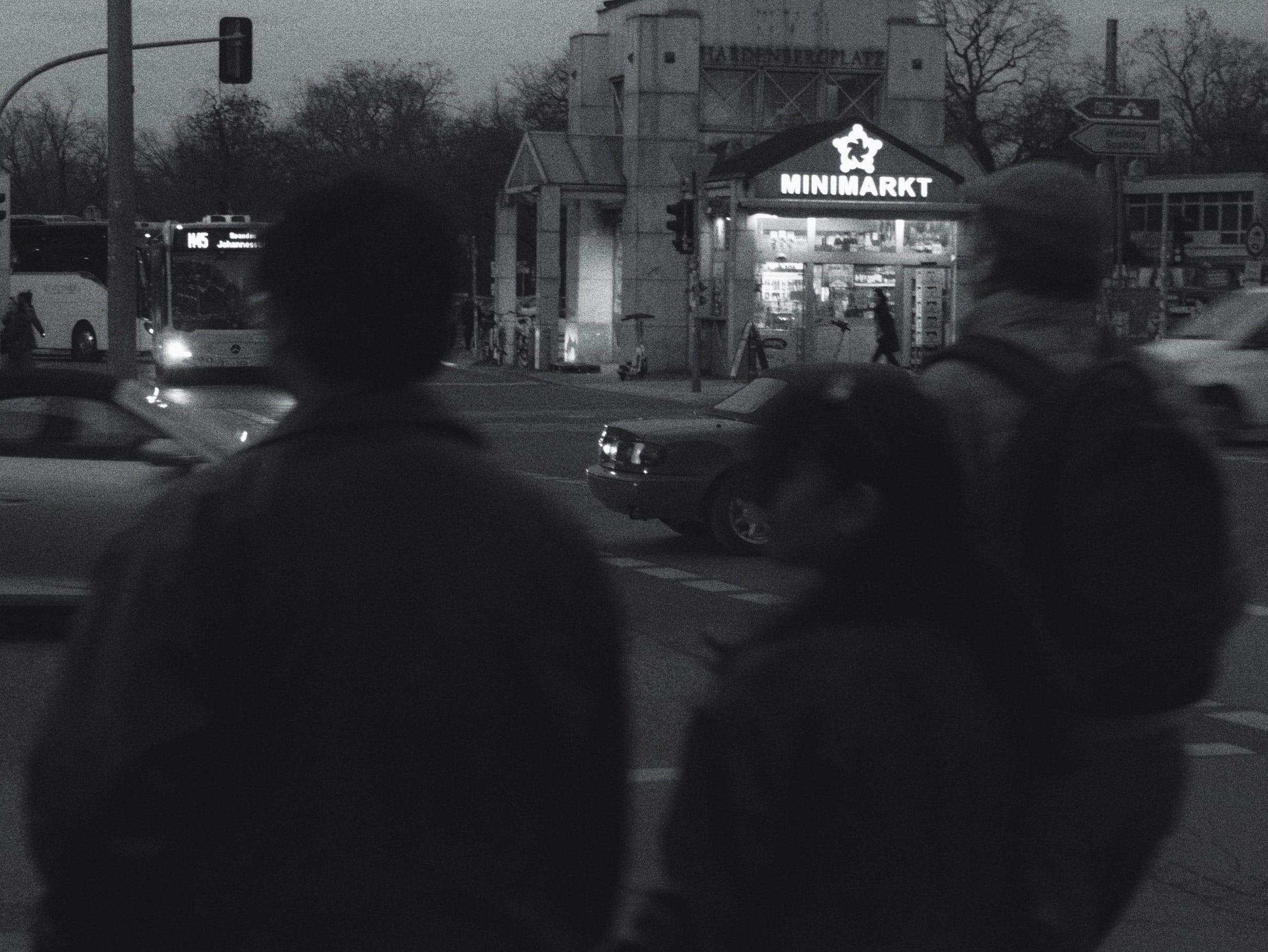 Two silhouettes in front of a lit kiosk