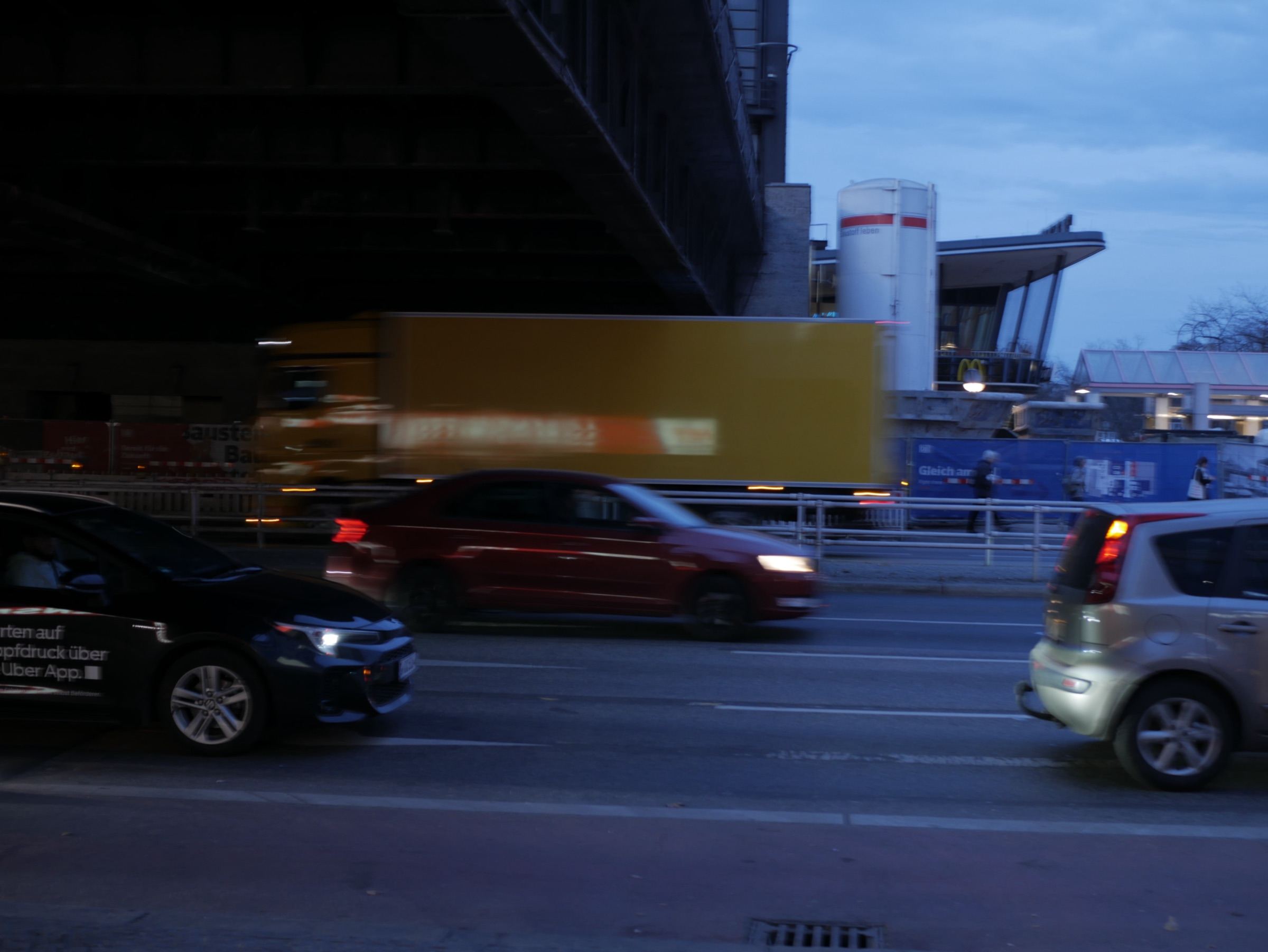 Traffic in motion beneath an overpass at dusk