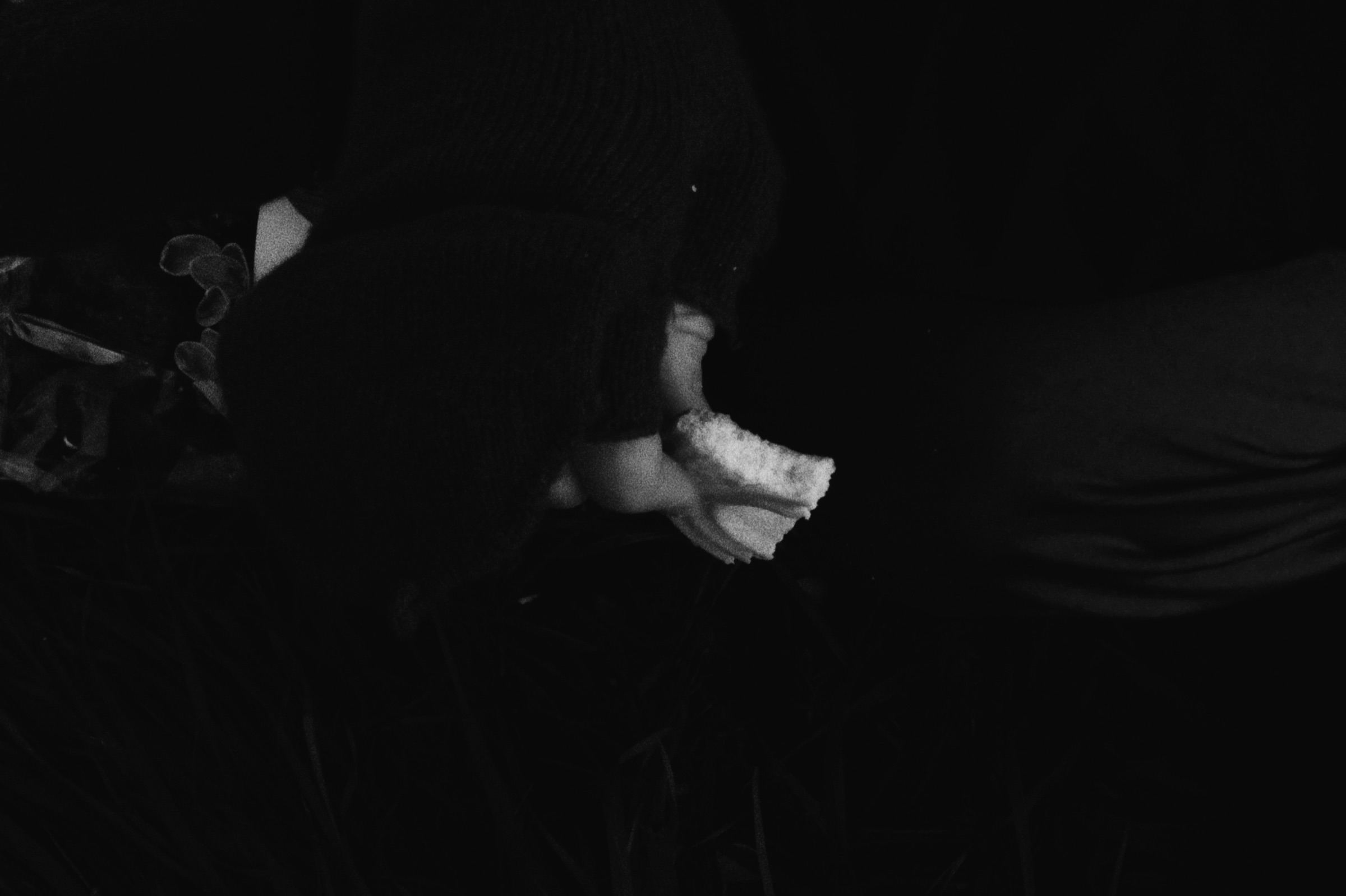 Hands holding a pale object in the dark