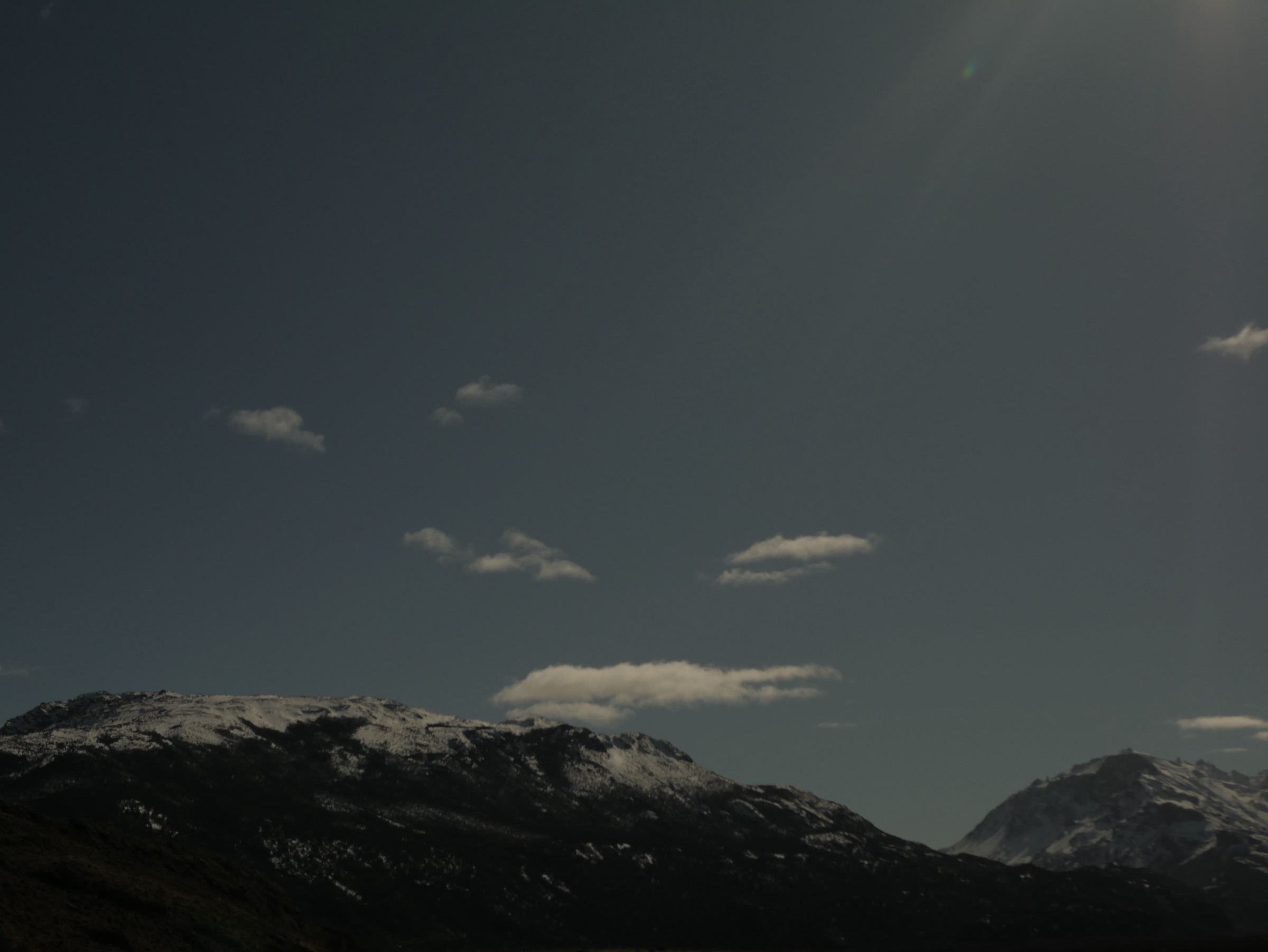 Small clouds over dark mountains