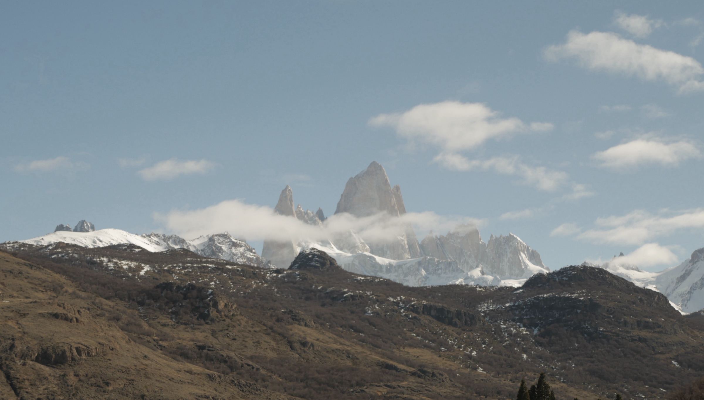 Jagged snow-covered peaks rising above clouds