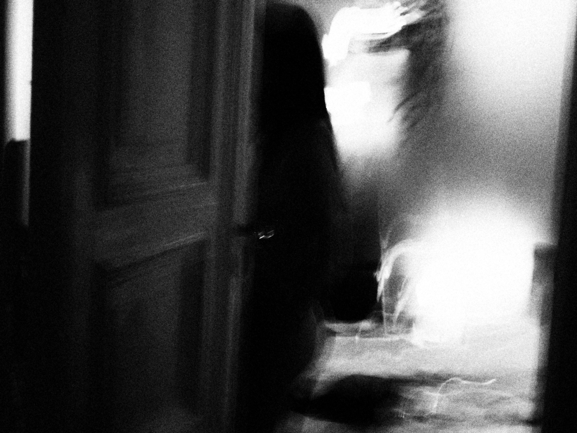 Figura movida junto a una puerta, inundada de luz blanca