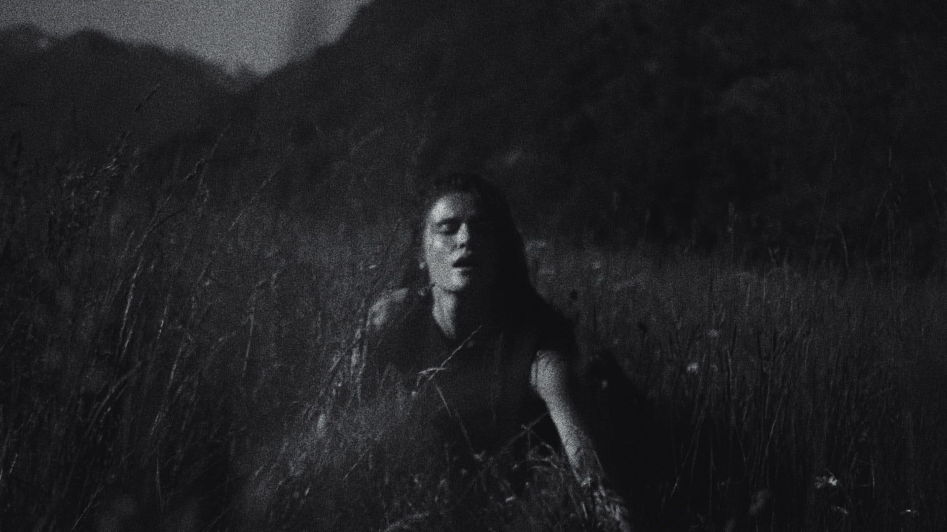 Woman among tall grass at night