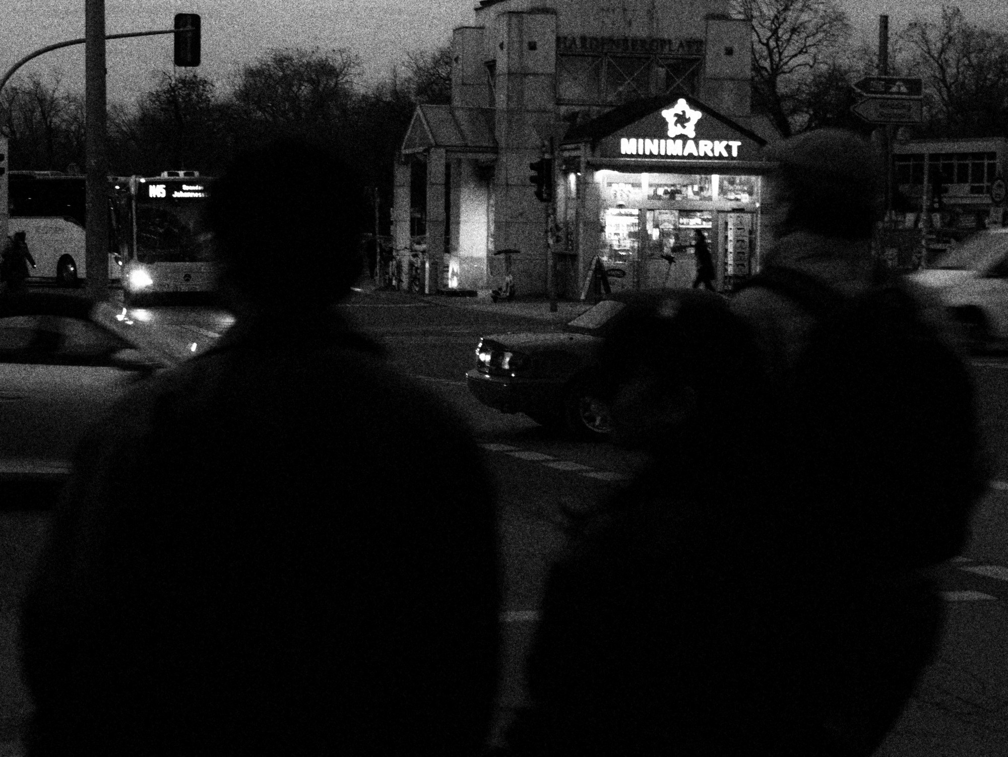 Dos siluetas frente a un minimarket iluminado