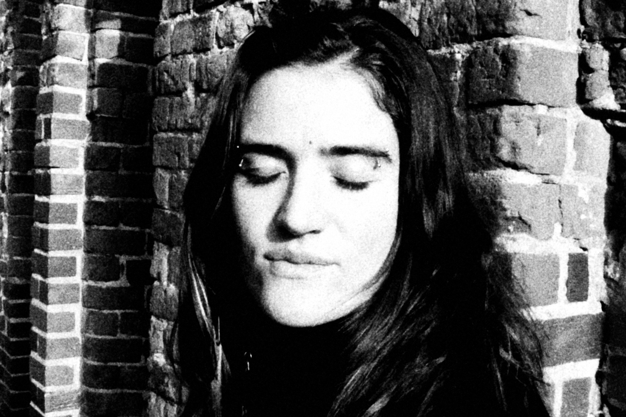 La misma foto en blanco y negro, la piel clara y el ladrillo oscuro